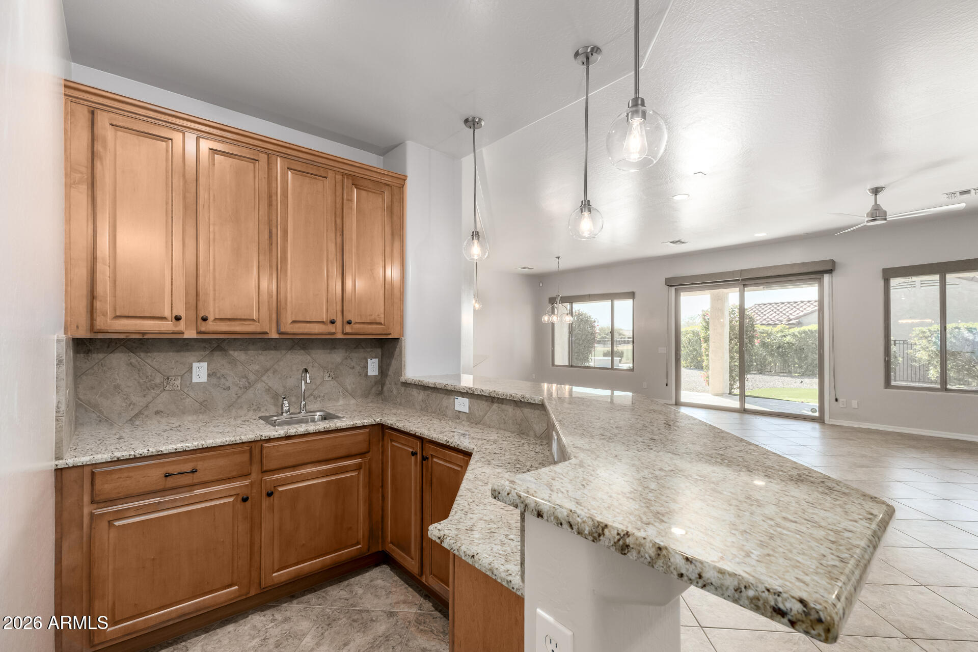 27119 West Burnett Road Buckeye, AZ 85396 - Photo 16 of 56 a kitchen with granite countertop sink stove and cabinets