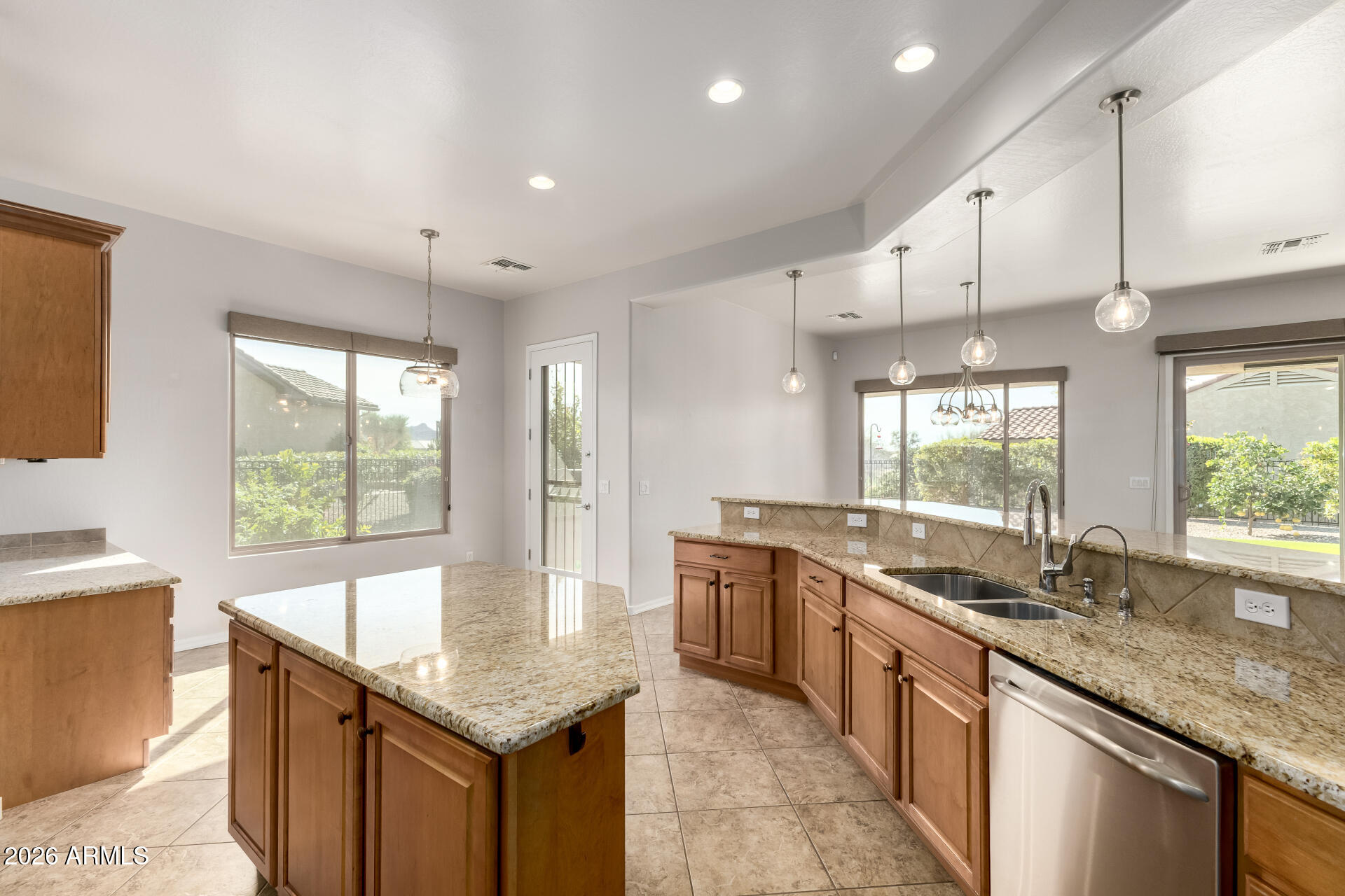 27119 West Burnett Road Buckeye, AZ 85396 - Photo 21 of 56 a kitchen with granite countertop kitchen island a sink stove and cabinets
