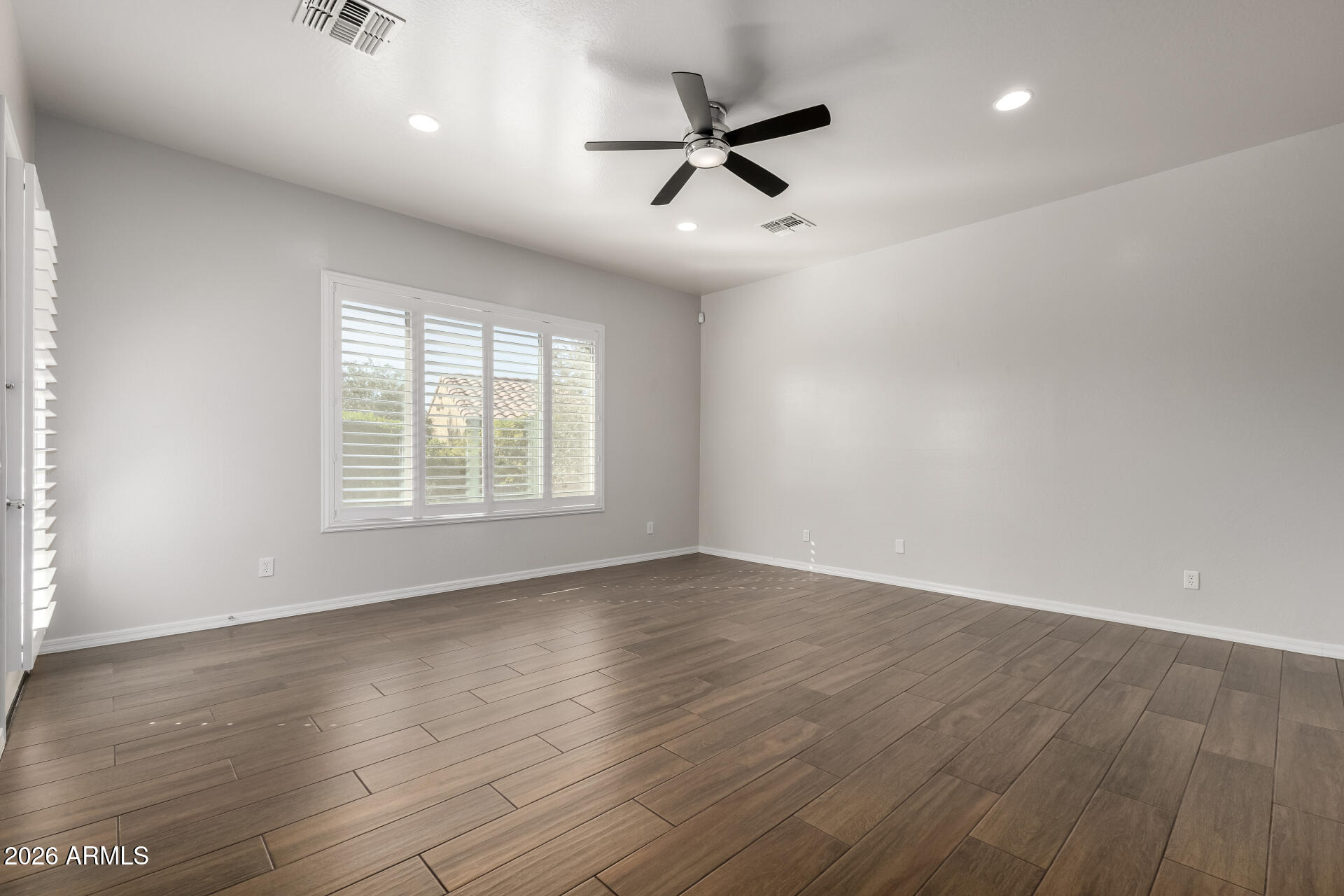 27119 West Burnett Road Buckeye, AZ 85396 - Photo 24 of 56 an empty room with wooden floor fan and windows