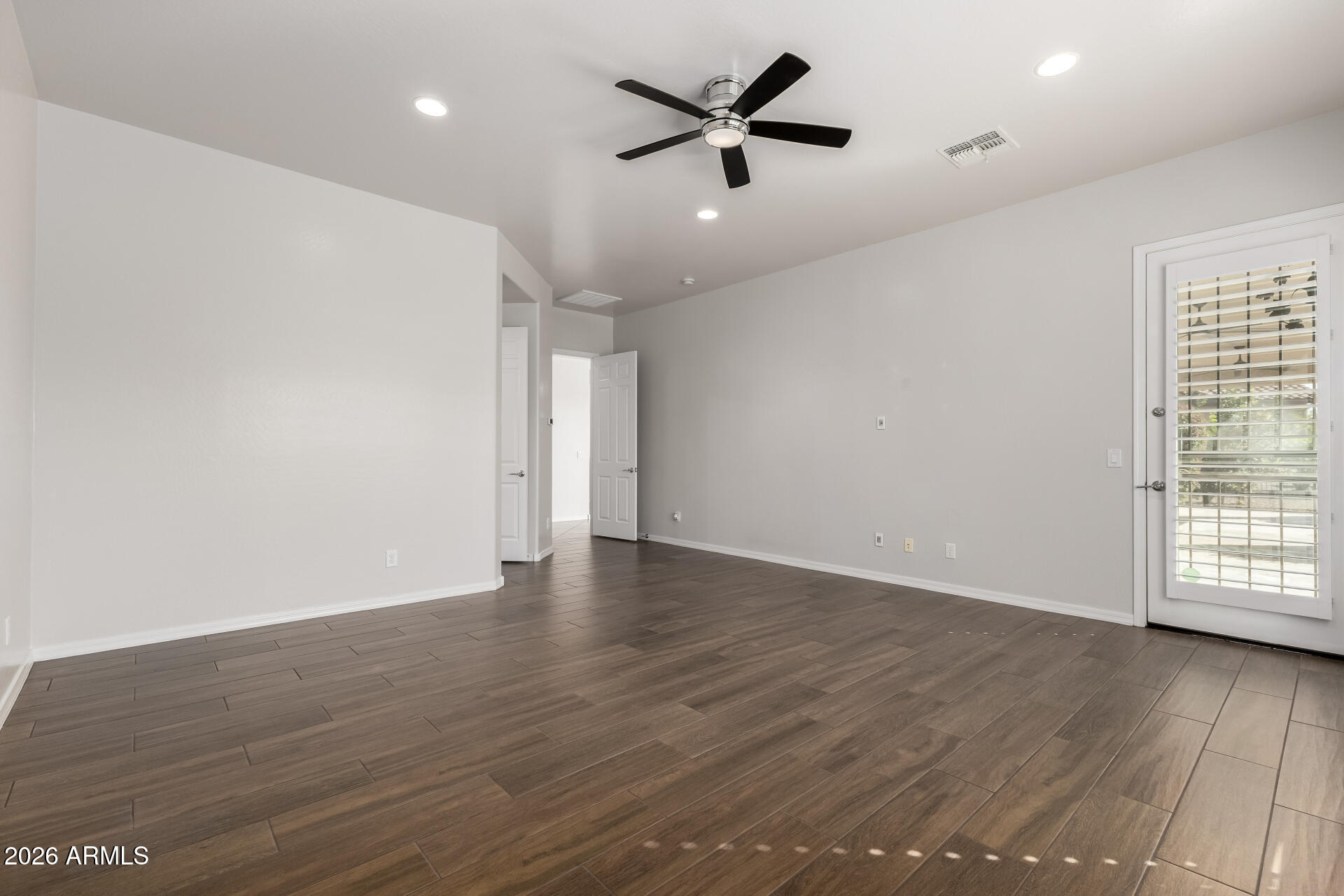 27119 West Burnett Road Buckeye, AZ 85396 - Photo 25 of 56 an empty room with wooden floor and windows