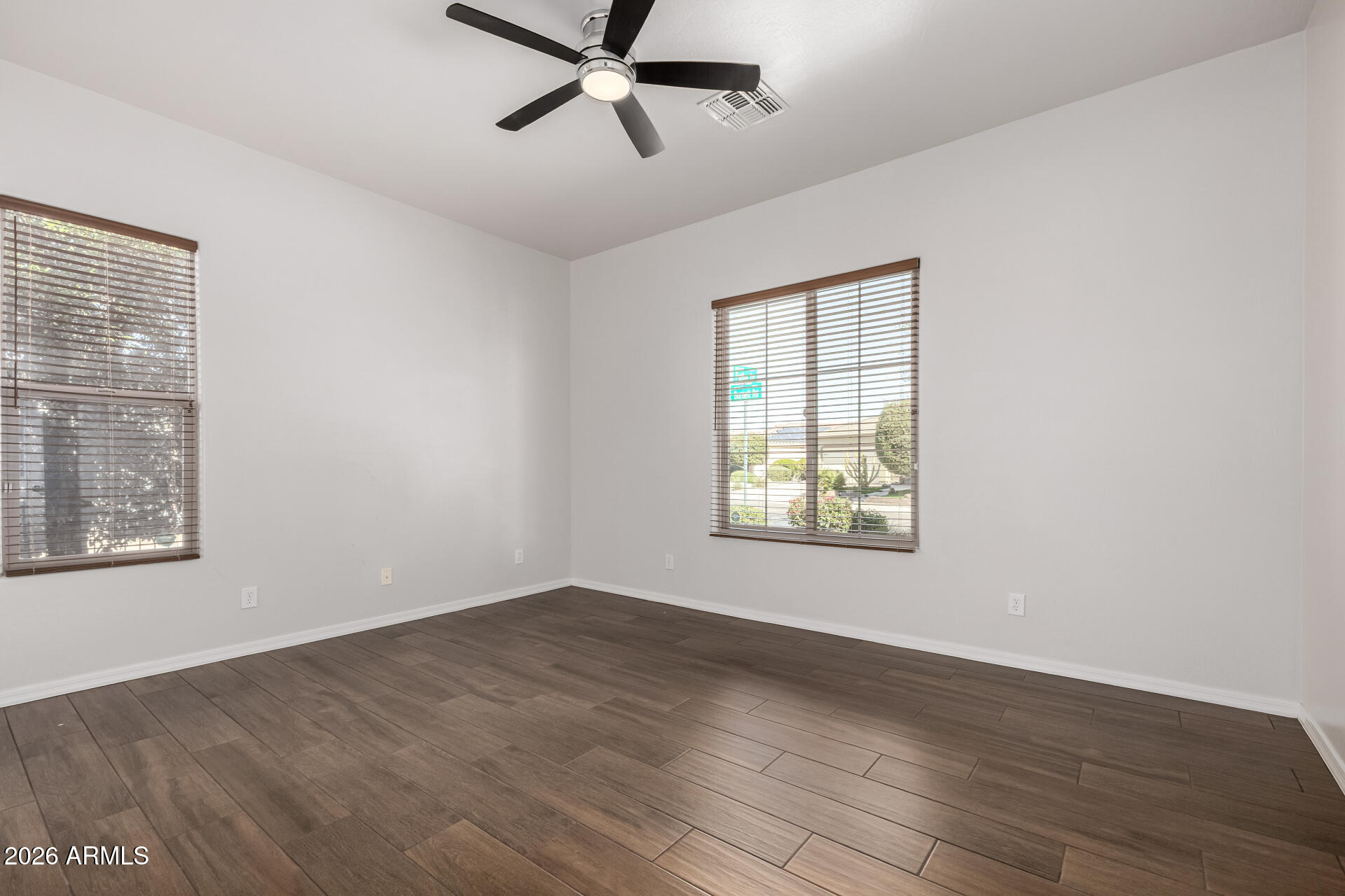 27119 West Burnett Road Buckeye, AZ 85396 - Photo 30 of 56 a view of an empty room with wooden floor and a window