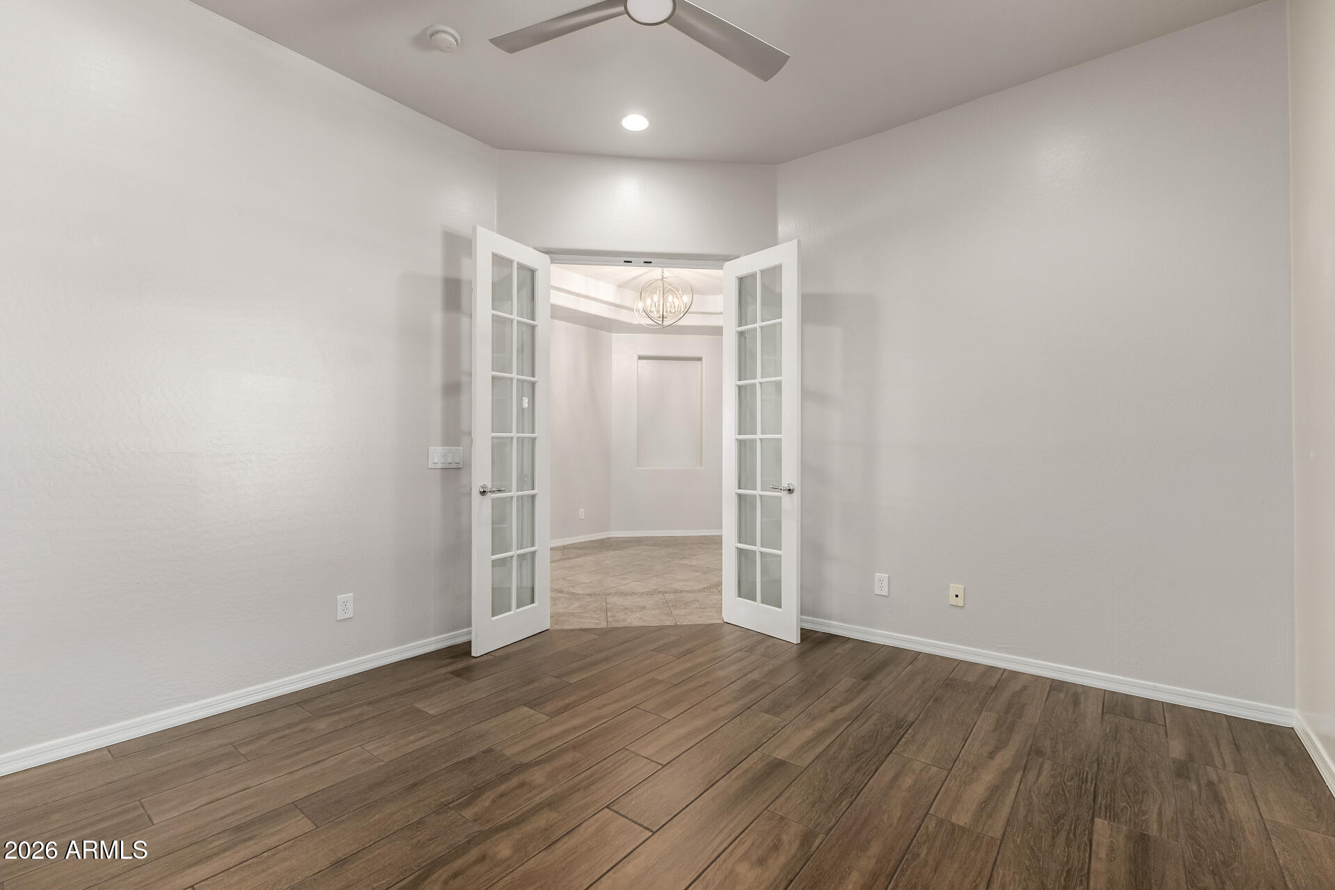 27119 West Burnett Road Buckeye, AZ 85396 - Photo 9 of 56 an empty room with wooden floor and windows