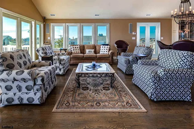 a living room with furniture floor to ceiling window and a table