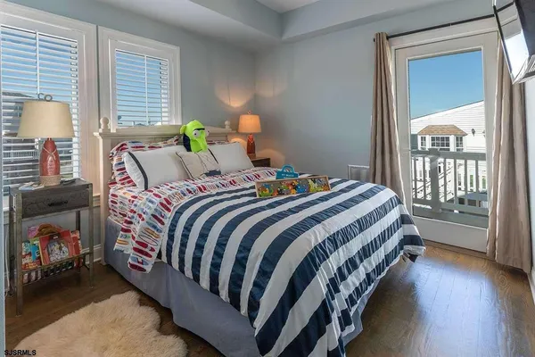 a bed sitting in a bedroom next to a window and a lamp