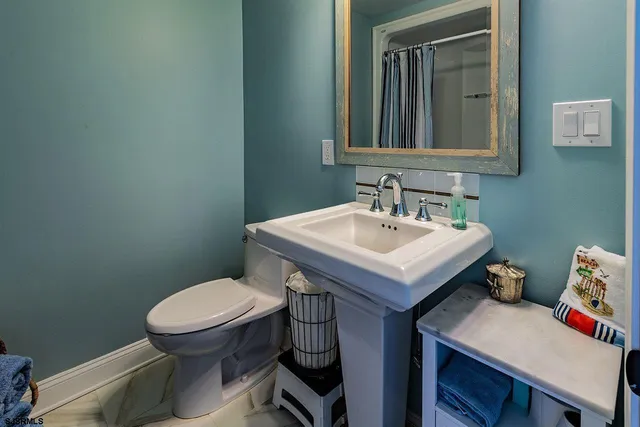 a bathroom with a sink a toilet and mirror