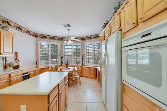 a dining room with furniture large windows and a chandelier