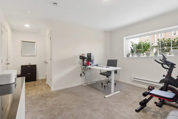a view of a workspace with furniture and a window