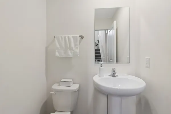 a bathroom with a sink a toilet and mirror