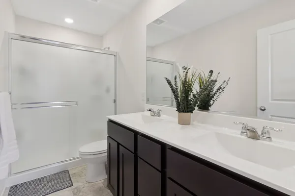 a bathroom with a granite countertop sink a toilet and shower