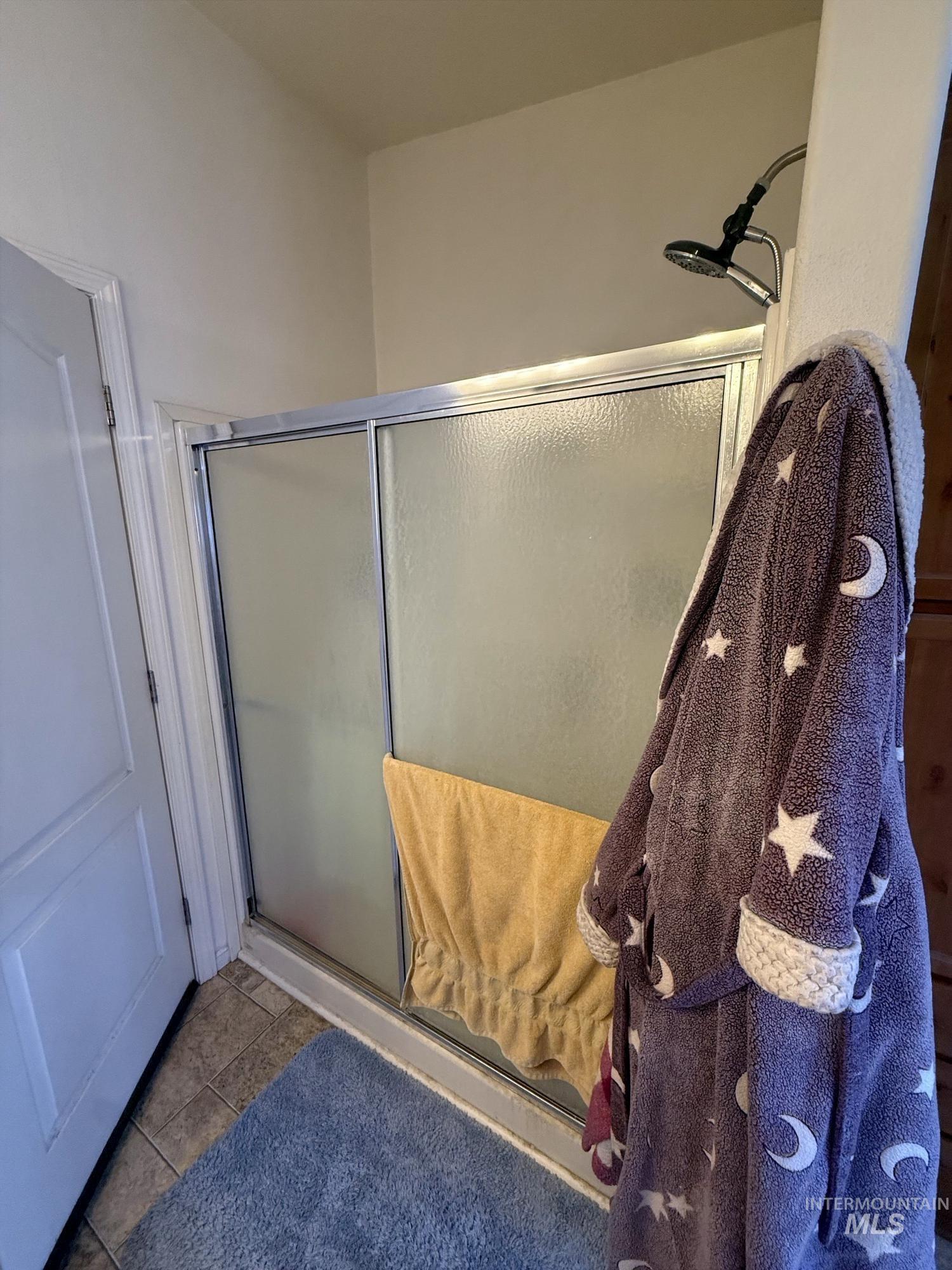 100 Ellsworth Street Vale, OR 97918 - Photo 14 of 25 Shower enclosure featuring sliding frosted glass doors, chrome trim, and an adjustable showerhead