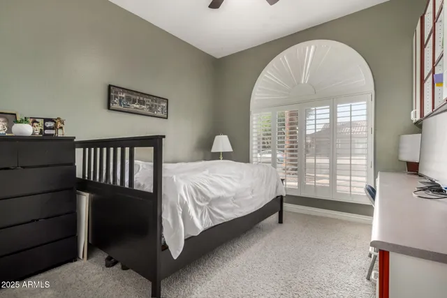 a bedroom with a bed and a flat tv screen on the dresser