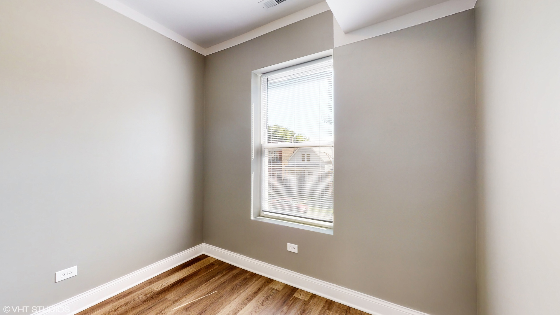 7316 South Peoria Street Chicago, IL 60621 - Photo 17 of 40 a view of an empty room with wooden floor and a window