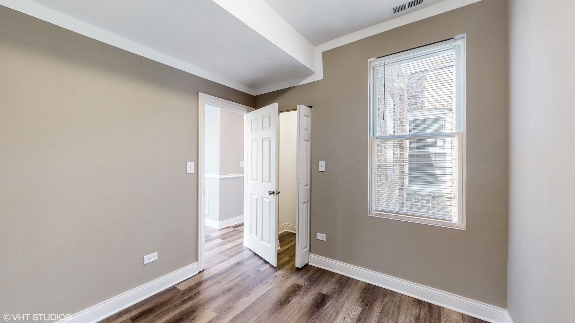 7316 South Peoria Street Chicago, IL 60621 - Photo 19 of 40 a view of an empty room with wooden floor and a window