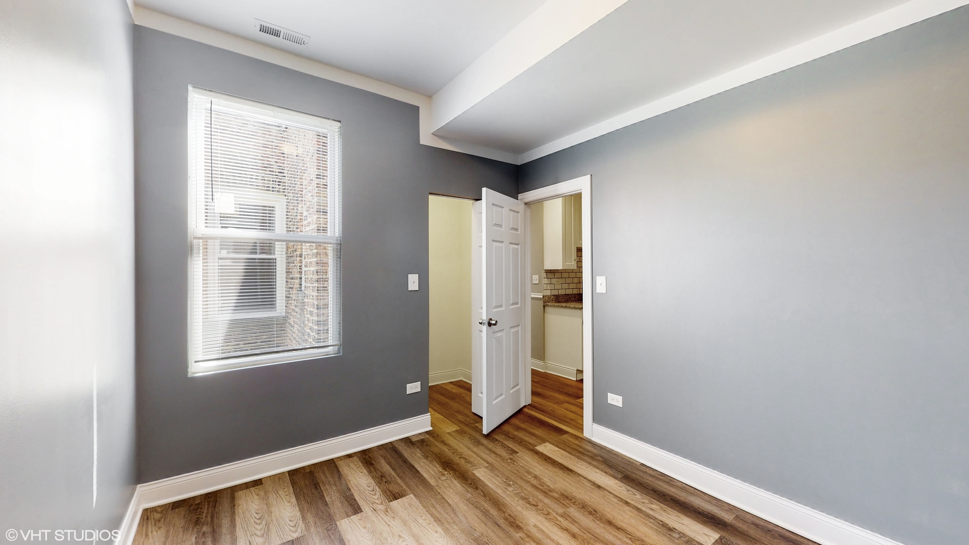 7316 South Peoria Street Chicago, IL 60621 - Photo 22 of 40 a view of an empty room with wooden floor and a window