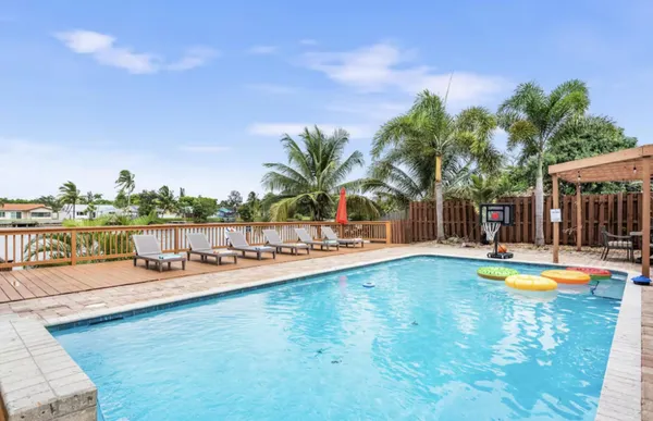 a view of a swimming pool with a patio and plants