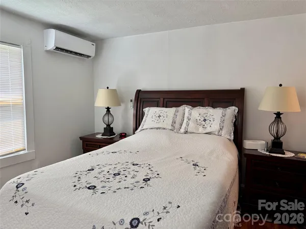 a bed sitting in a bedroom next to a window with lamp