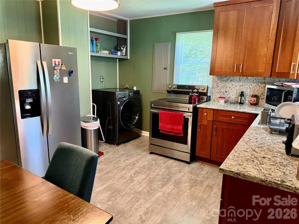 a kitchen with stainless steel appliances granite countertop a refrigerator a stove top oven a sink and dishwasher