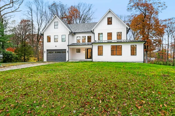 a front view of a house with a yard and trees