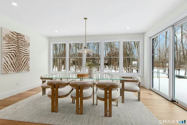 a dining room with furniture and a floor to ceiling window