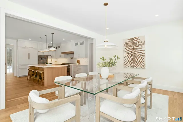 a kitchen with kitchen island a stove a table and chairs in it