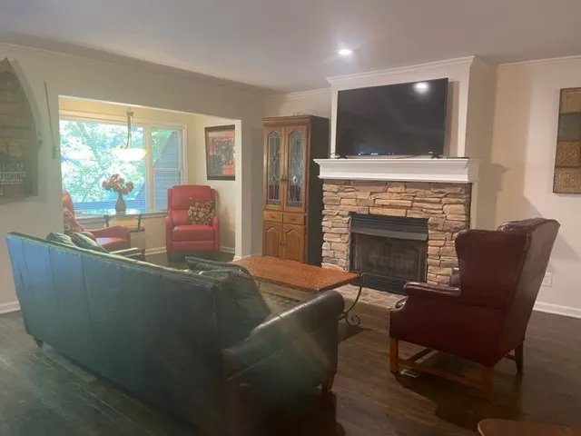a living room with furniture a fireplace and a flat screen tv