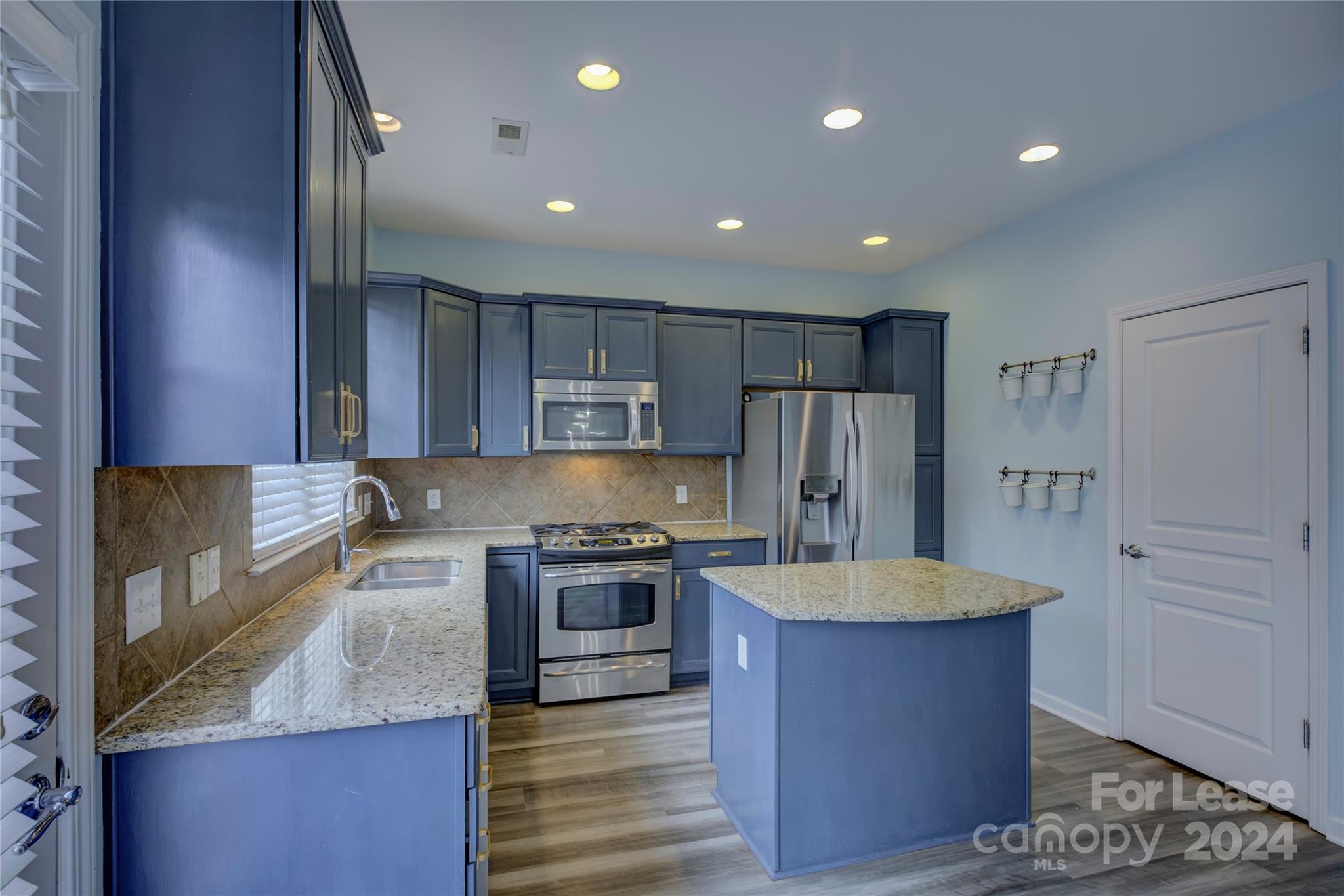 568 6th Baxter Crossing Fort Mill, SC 29708 - Photo 11 of 48 a large kitchen with stainless steel appliances granite countertop a stove a refrigerator and a sink with wooden cabinets