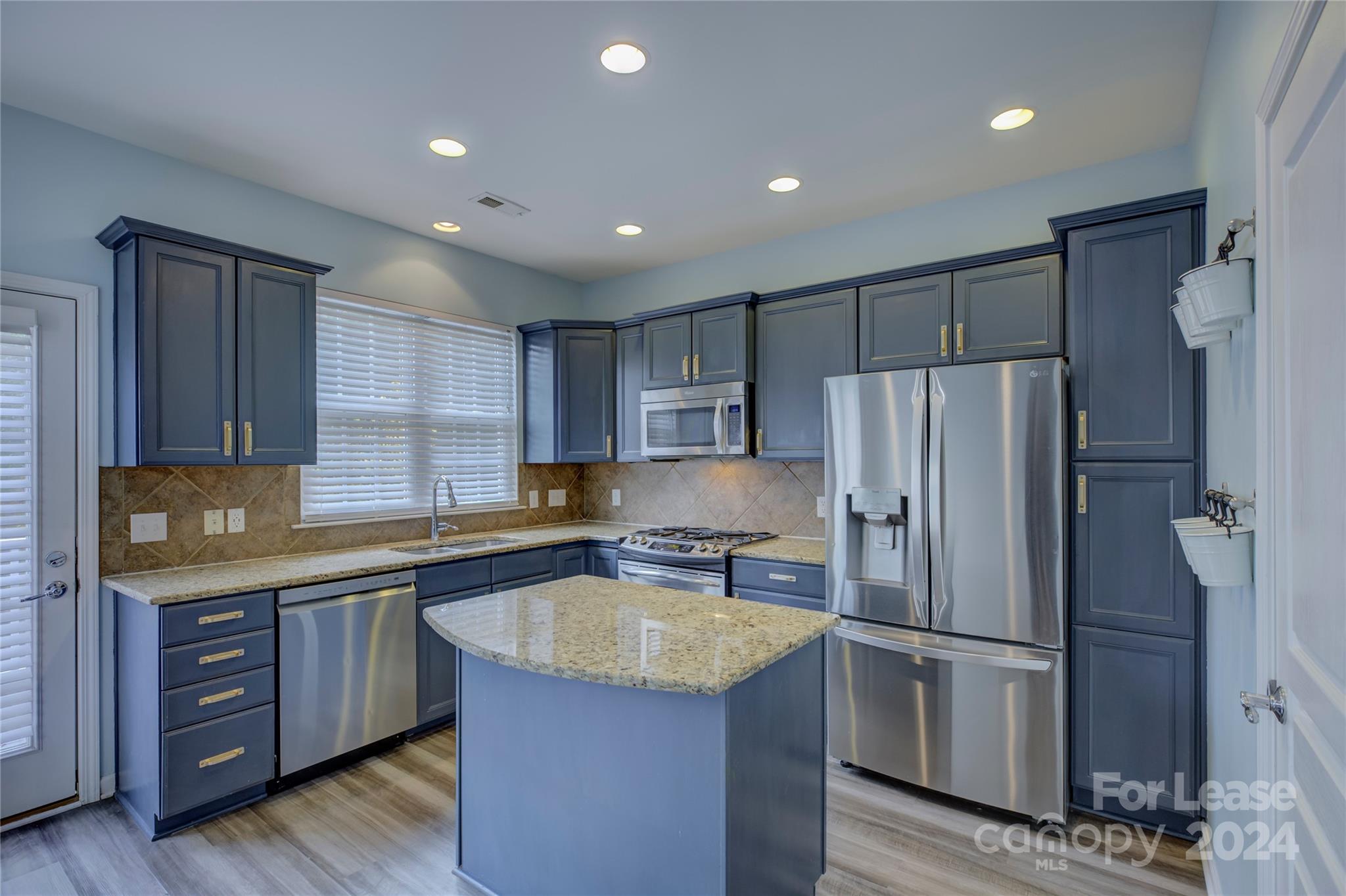 568 6th Baxter Crossing Fort Mill, SC 29708 - Photo 10 of 48 a kitchen with granite countertop a refrigerator and wooden cabinets