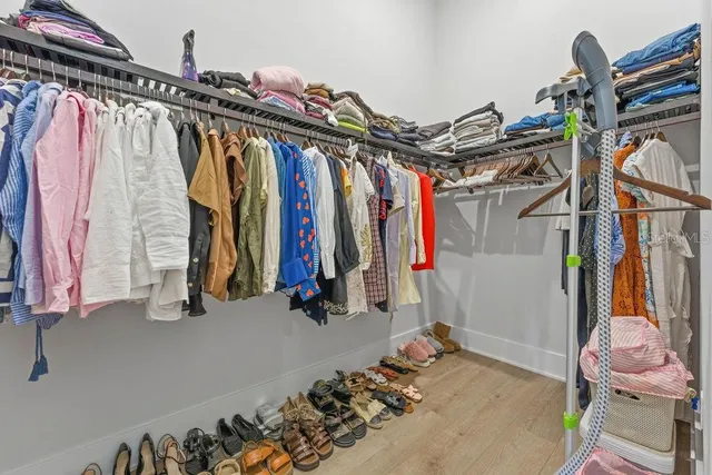 a view of walk in closet with clothes and shoes