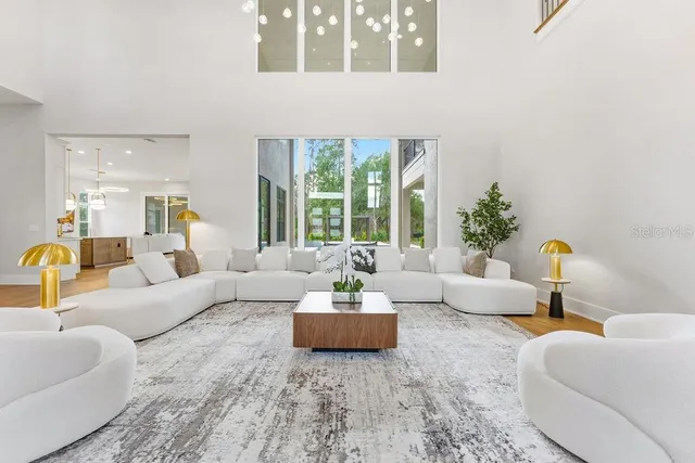 a living room with furniture and floor to ceiling windows