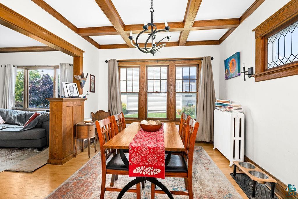23 5th Street Proctor, MN 55810 - Photo 12 of 32 Dining area featuring coffered ceiling, light hardwood / wood-style flooring, an inviting chandelier, and beamed ceiling
