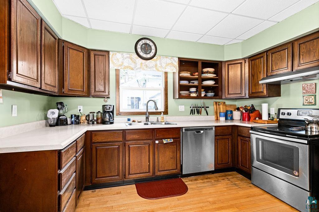 23 5th Street Proctor, MN 55810 - Photo 13 of 32 Kitchen with light wood-type flooring, appliances with stainless steel finishes, a paneled ceiling, and sink
