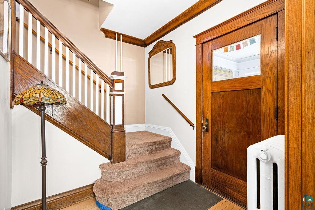 23 5th Street Proctor, MN 55810 - Photo 6 of 32 Entryway with hardwood / wood-style flooring, radiator heating unit, and crown molding