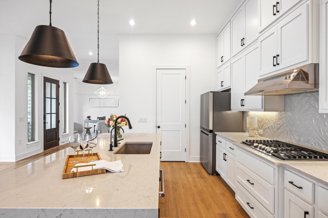 1122 Silver Dollar Trail Georgetown, TX 78628 - Photo 13 of 35 a kitchen with stainless steel appliances kitchen island granite countertop a sink a stove and a refrigerator