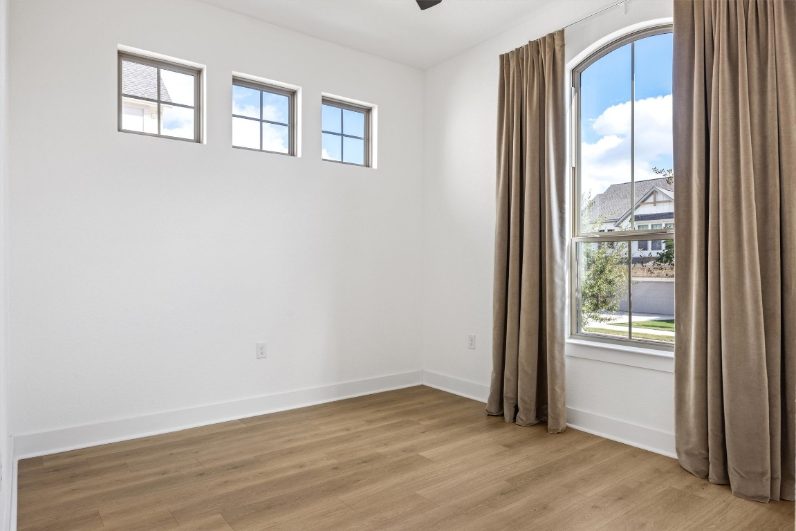 1122 Silver Dollar Trail Georgetown, TX 78628 - Photo 19 of 35 a view of an empty room with wooden floor and a window