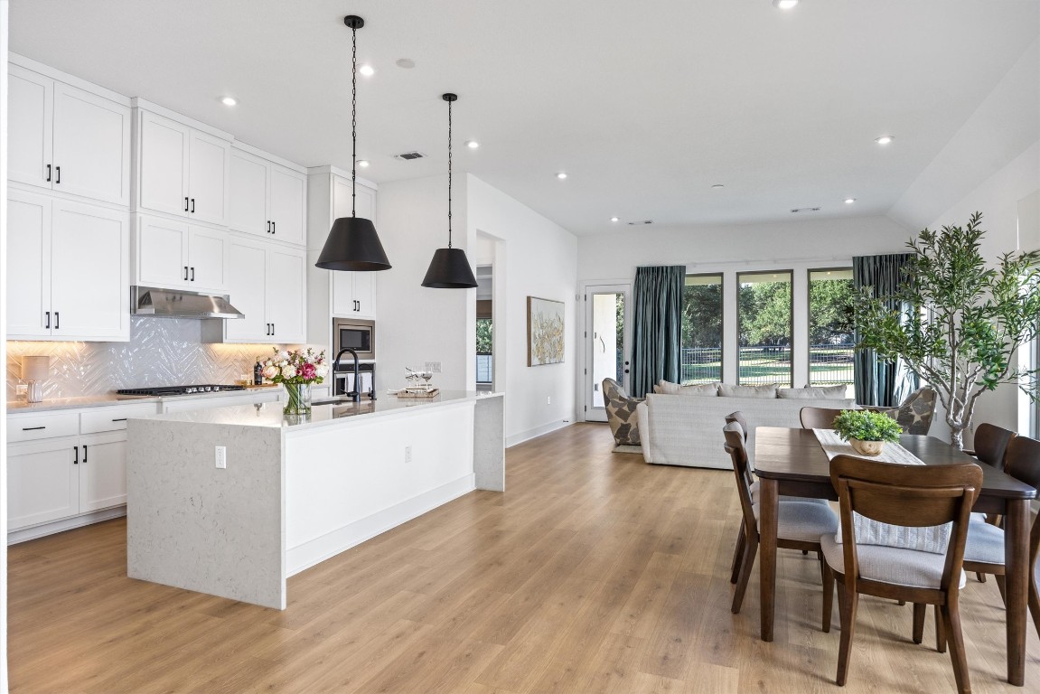 1122 Silver Dollar Trail Georgetown, TX 78628 - Photo 9 of 35 a kitchen with stainless steel appliances kitchen island wooden cabinets and white appliances