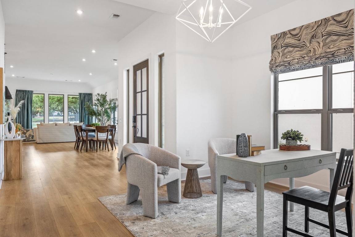 1122 Silver Dollar Trail Georgetown, TX 78628 - Photo 10 of 35 a view of a dining room with furniture a chandelier and wooden floor