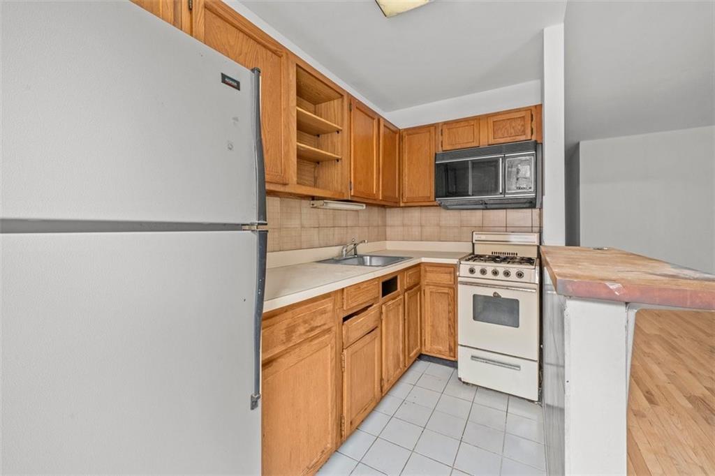 191 Clinton Street, Unit 2B Brooklyn, NY 11201 - Photo 6 of 10 a kitchen with stainless steel appliances granite countertop a sink and a stove top oven