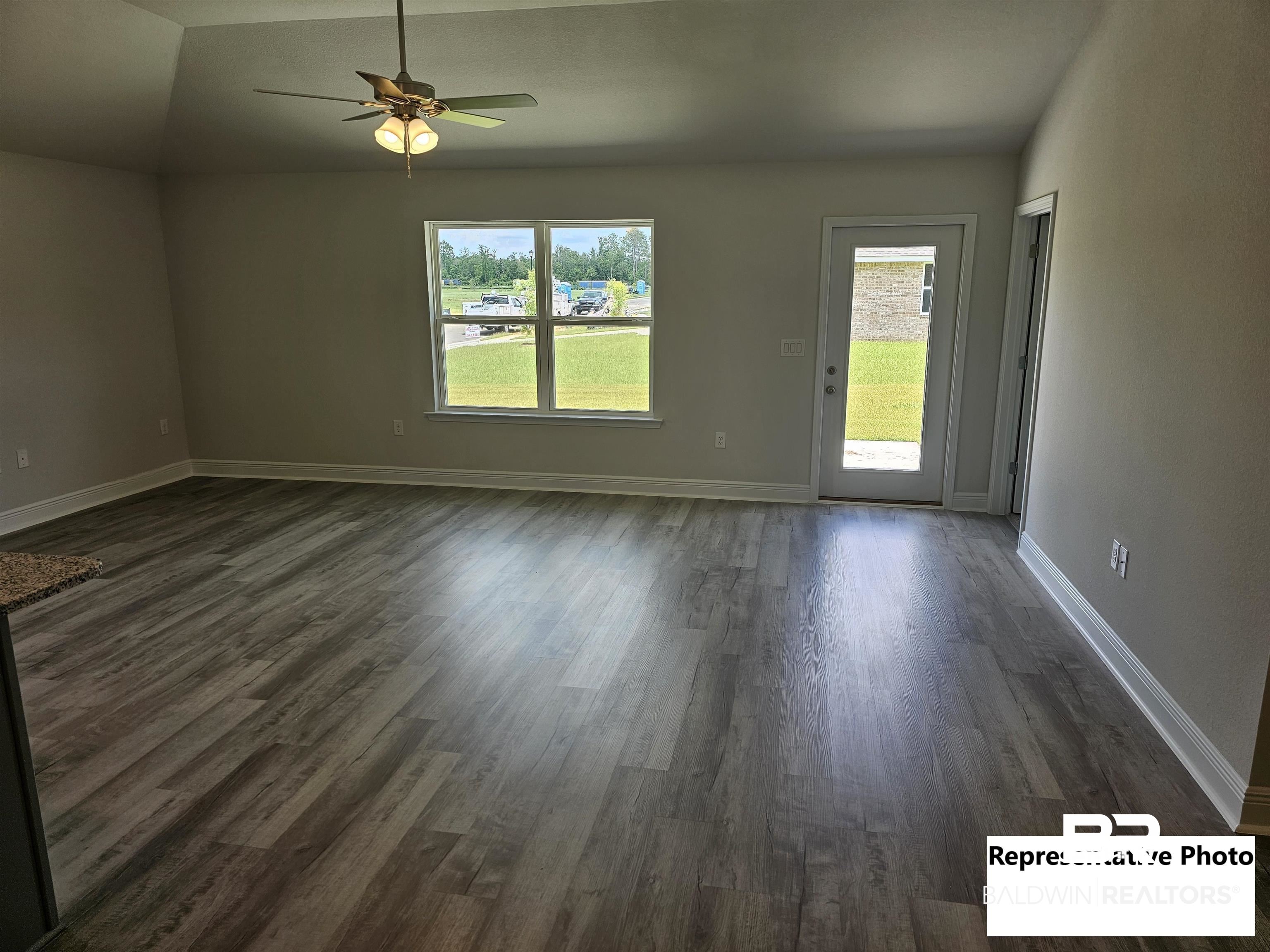 665 Revere Street Foley, AL 36535 - Photo 3 of 10 Spare room featuring ceiling fan, dark hardwood / wood-style flooring, and lofted ceiling