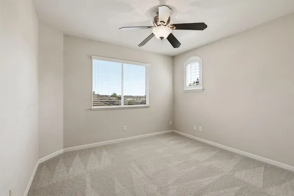 an empty room with a chandelier fan