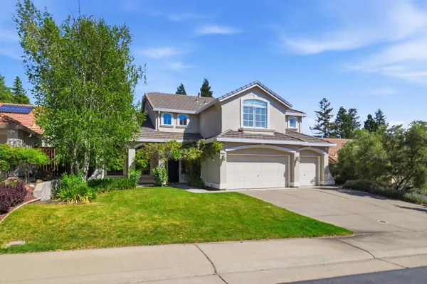 a front view of a house with a garden and yard