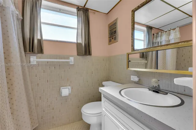 a bathroom with a granite countertop sink toilet a mirror and shower