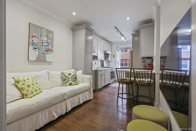 a living room with furniture and a dining table with wooden floor