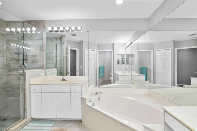 a spacious bathroom with a sink a large mirror and shower