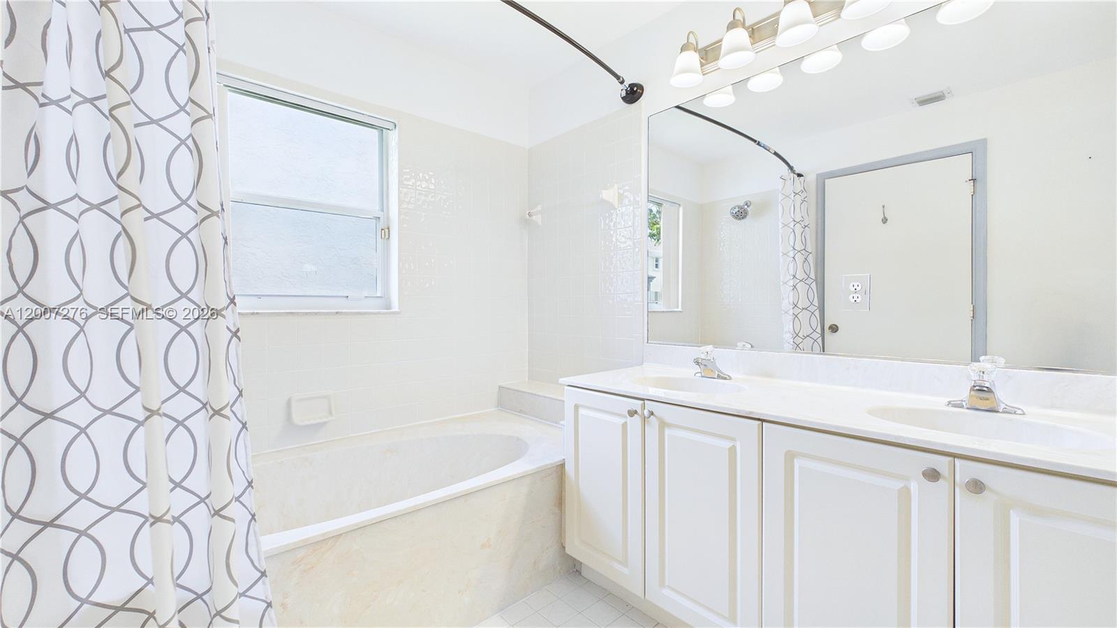 17626 Southwest 20th Street Miramar, FL 33029 - Photo 14 of 27 a bathroom with a granite countertop sink a mirror and a bathtub