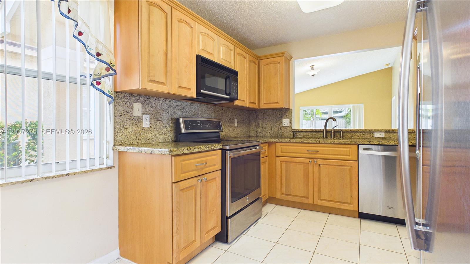 17626 Southwest 20th Street Miramar, FL 33029 - Photo 10 of 27 a kitchen with stainless steel appliances granite countertop a stove a sink and a microwave