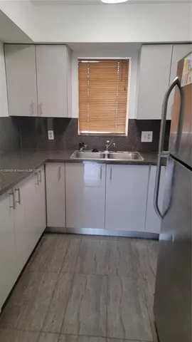 a kitchen with a sink a cabinets and window