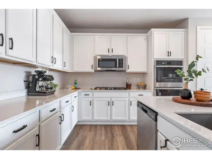 a kitchen with granite countertop a sink stove and cabinets