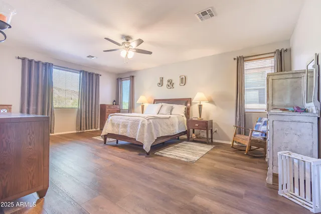 a spacious bedroom with a bed a window and dresser