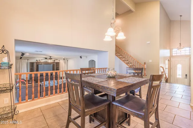a dining room with wooden floor a chandelier a wooden table and chairs