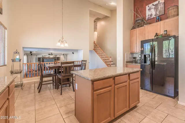 a kitchen with stainless steel appliances granite countertop a table chairs and a refrigerator